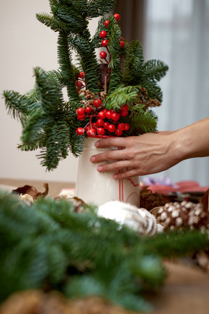 Woman making Christmas arrangement with fir branches. craft handmade decor.の写真素材