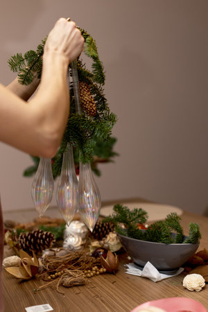 Woman making Christmas arrangement with fir branches. craft handmade decor.の写真素材