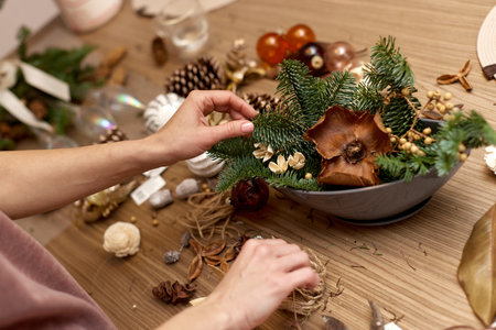 Woman making Christmas arrangement with fir branches. craft handmade decor.の写真素材