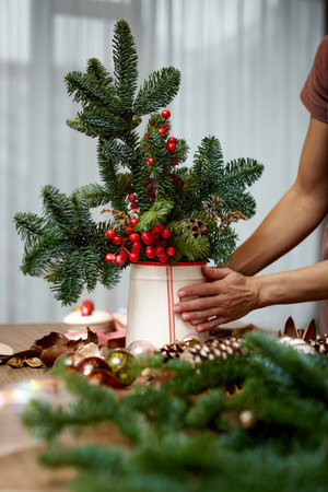 Woman making Christmas arrangement with fir branches. craft handmade decor.の写真素材