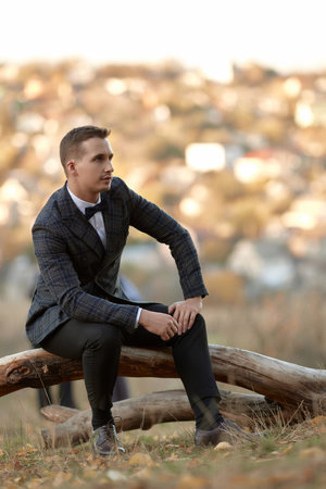 Handsome young man in classic checked suit outdoorの写真素材