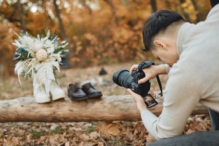 wedding photographer taking pictures of bride and groom shoes, wedding bouquet outdoor.の写真素材