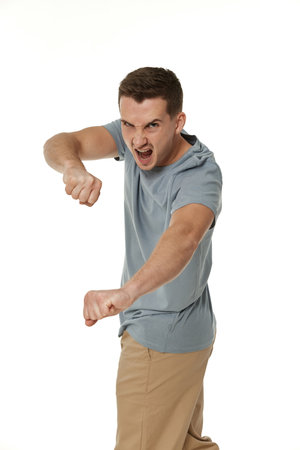 annoyed angry man fighting on white studio backgroundの写真素材