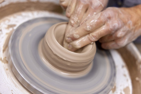male hands making ceramic cup on pottery wheel, Close-upの写真素材