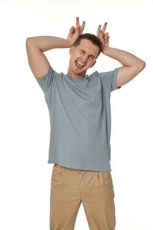 portrait of young funny man grimacing on white backgroundの写真素材