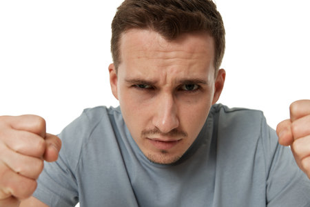 angry guy looking at camera on white studio backgroundの写真素材