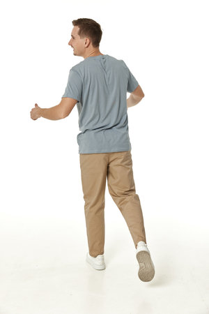 portrait of young smiling man on white background, rear viewの写真素材