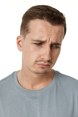 offended frustrated young man on white background. sadnessの写真素材