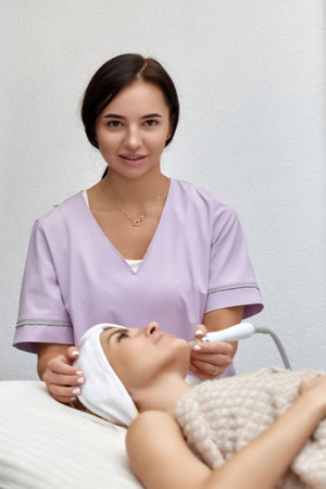 cosmetologist doing peeling procedure for female client in beauty salonの写真素材