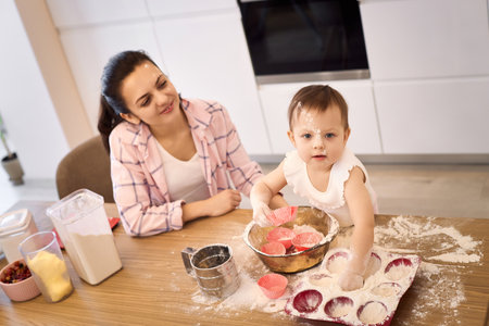 mother and little baby girl baking in the kitchen, bake cookies. happy time togetherの写真素材