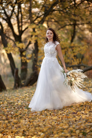 beautiful happy bride holding wedding autumn bouquet in natureの写真素材