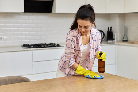 young woman in gloves cleaning and wiping wooden table with microfiber cloth. chores at home. Housekeepingの写真素材
