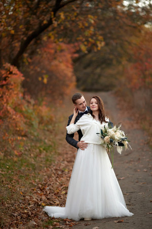 happy bride in white wedding dress and groom standing outdoor on natural backgroundの写真素材