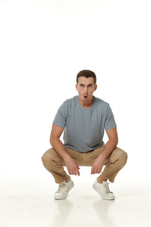 surprised guy looking at camera on white studio backgroundの写真素材