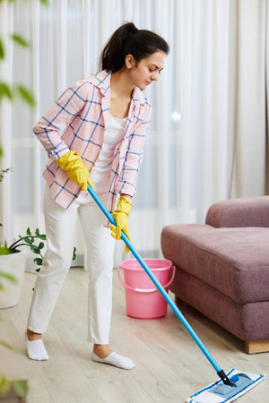 young woman cleaning and washing floor at living room, daily housekeepingの写真素材