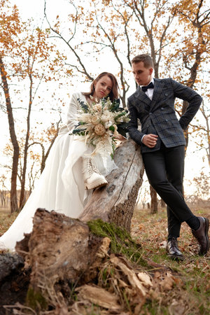 beautiful sensual bride in white wedding dress and groom standing outdoor on natural backgroundの写真素材