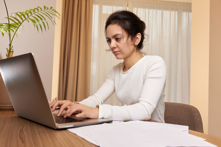 beautiful businesswoman using laptop and communicates with customer on internet at homeの写真素材