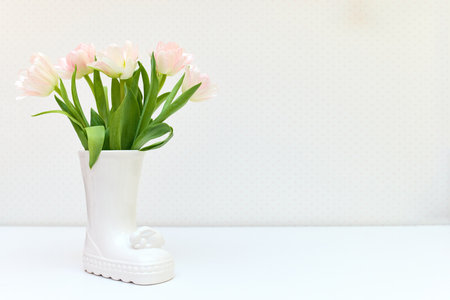bouquet of tulips in Easter bunny vase on white table. copy spaceの写真素材