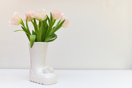 bouquet of tulips in Easter bunny vase on white table. copy spaceの写真素材