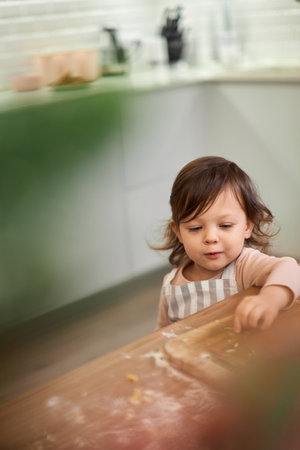 cute little child girl cooking cookies .の写真素材