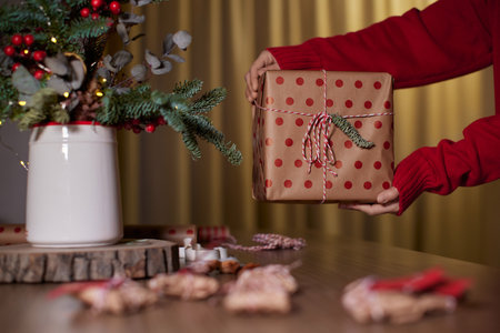 female hands holding Christmas gift box at home, New Years Eveの写真素材