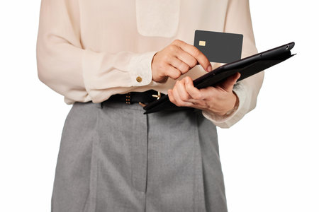 woman in white blouse and grey pants using credit card and digital tablet on white backgroundの写真素材
