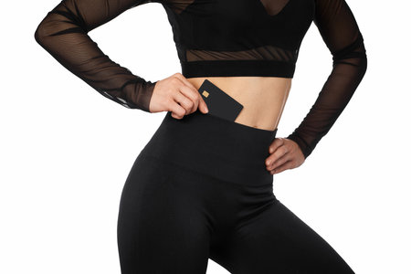 athletic fitness woman with black credit card on white background.の写真素材