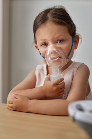 cute little toddler girl making inhalation with nebulizerの写真素材
