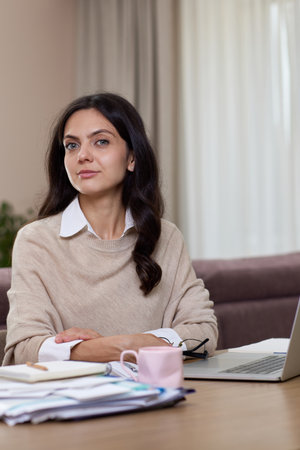 Portrait of calm woman looking at camera at home. Successful lady working at home.の写真素材