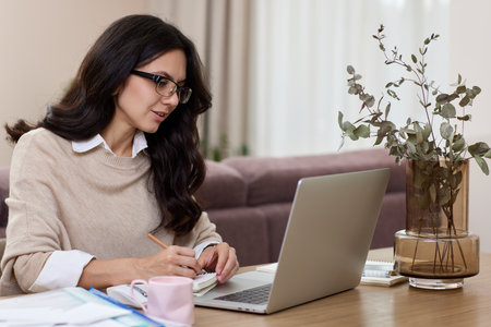 pretty woman working at home office, female worker using laptop computer for contact with clients onlineの写真素材