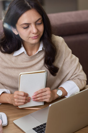 Beautiful woman in shirt using laptop while working at homeの写真素材