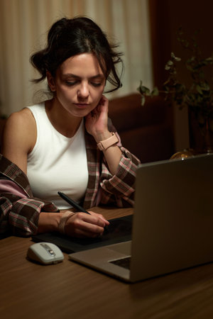 beautiful professional female retoucher woman working at home workspace using digital graphic tablet and laptopの写真素材