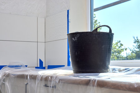 wall repair tools. plaster bucket on kitchen countertop. renovation work, copy spaceの写真素材