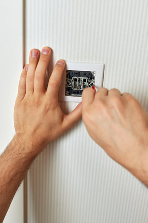 electrician working on light switch using screwdriver inside, close-upの写真素材