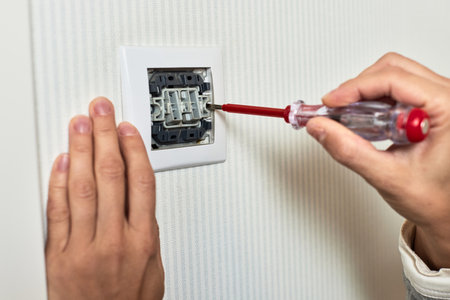 electrician installing electric light switch using screwdriver at home, close-upの写真素材