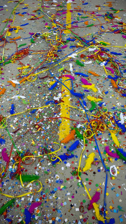 Bright confetti and colorful streamers scattered across the road after a festive celebration or parade.の素材