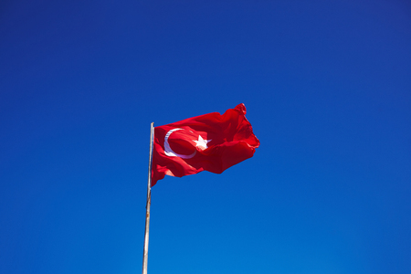 Turkish flag on wind with pure blue sky on backgroundの写真素材