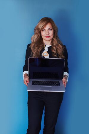 Woman in business suit with laptop in hands