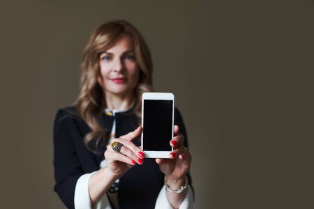 Woman shows her mobile phone screenの写真素材