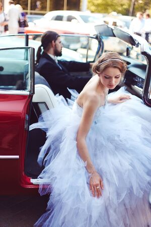Young bride on retro car with driverの写真素材