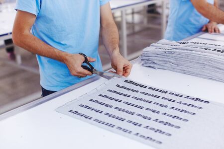 The worker at the factory cuts the fabric with scissors and with cutting machine