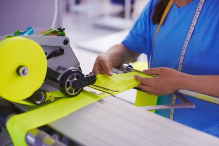 The worker at the factory cuts the fabric with scissors and with cutting machine