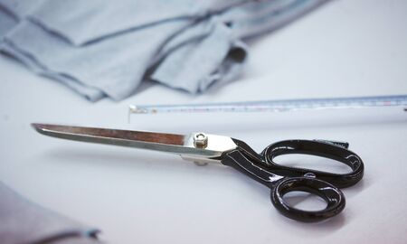 The worker at the factory cuts the fabric with scissors and with cutting machine