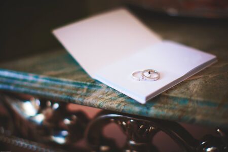 Platinum wedding rings on hotel notebookの写真素材