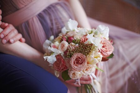 Tender pastel color boho style wedding bouquet in pregnant bride handsの写真素材