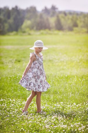 Beautiful girl dancing on grass sunny day happiness childhood conceptの写真素材