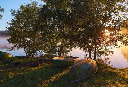Peaceful morning landscape with fog and boatsの写真素材