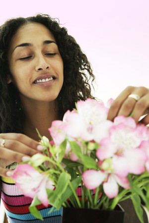 Female arranging and smelling flowersの写真素材