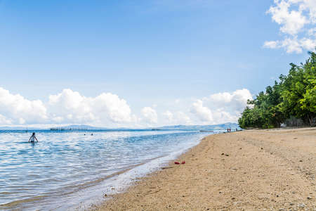 An empty beach with golden sand and blue skiesの写真素材
