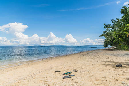 An empty beach with golden sand and blue skiesの写真素材